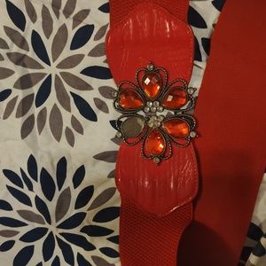 Vintage rich stretch belt embellished with fancy fower fastens behind folowers